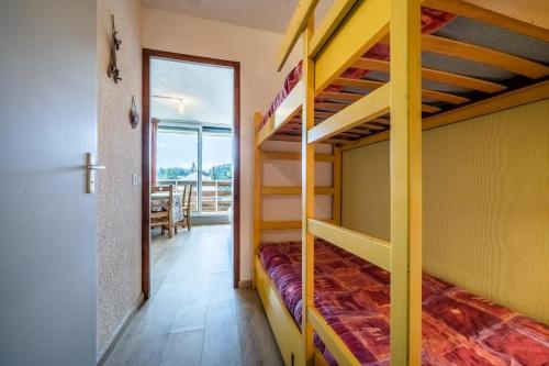 a bedroom with bunk beds and a dining room at Les Pralyssimes in Taninges