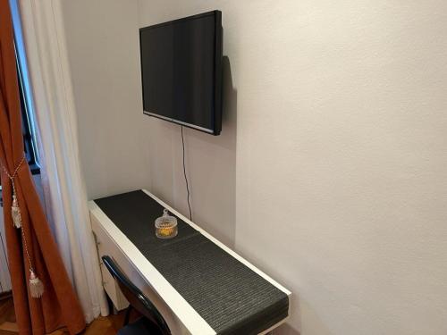 a tv on the corner of a room with a table at Rooms Aida in Pula