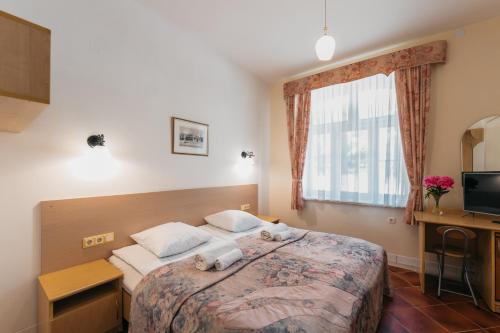a hotel room with a bed and a window at Villa Bachmann - Kuršių kiemas in Juodkrantė