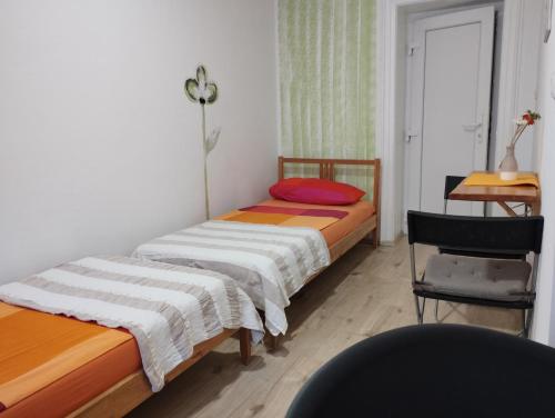 1 dormitorio con 2 camas, escritorio y silla en Old Town Room Pula, en Pula