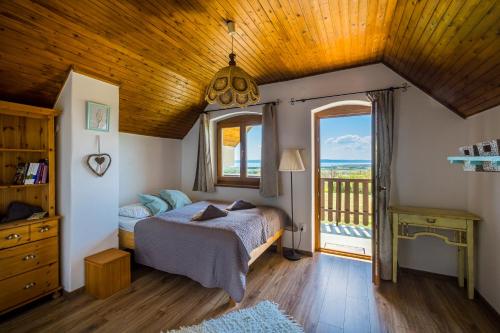 ein Schlafzimmer mit einem Bett und einem großen Fenster in der Unterkunft Tagyon Birtok Panoráma Apartman in Tagyon