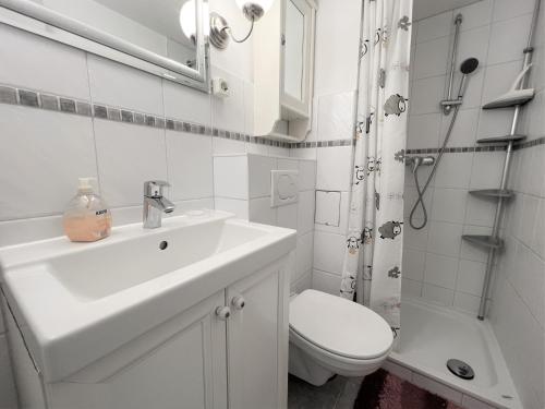 a white bathroom with a sink and a toilet at Panoramic App A09-5 in Sierksdorf