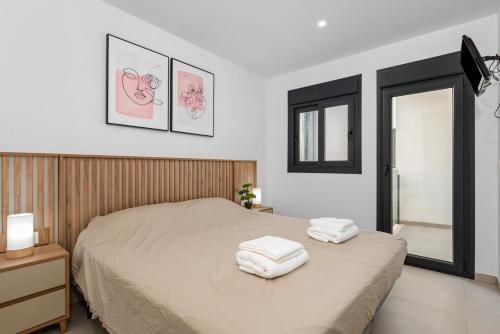 1 dormitorio con 1 cama con 2 toallas en Tokai Beach Residences, en San Pedro del Pinatar