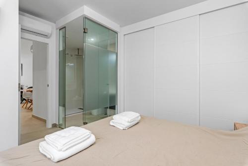 two white towels sitting on a bed in a room at Tokai Beach Residences in San Pedro del Pinatar