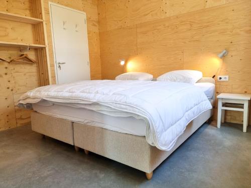 a bedroom with a large bed in a wooden room at Vakantiewoning Studio 51 OK49 in Oostkapelle
