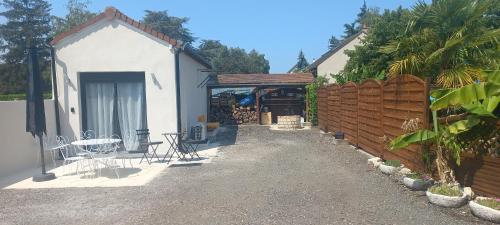 a house with a patio with a table and a fence at au p'tit logis montlouisien in Montlouis-sur-Loire