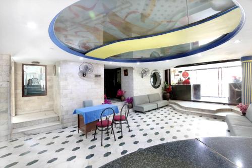 a living room with a blue table and chairs at Hotel O Rajmahal in Jalandhar