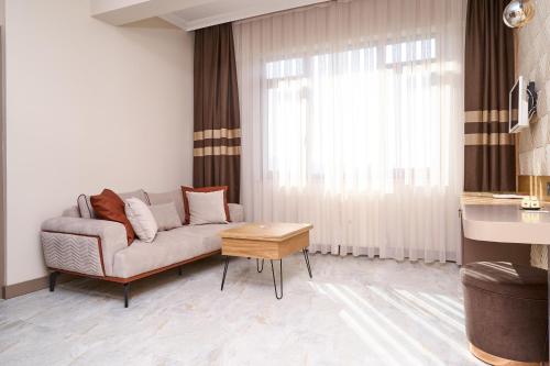 a living room with a couch and a table at Buyuk Truva Hotel in Canakkale