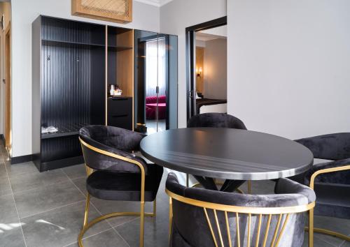 a dining room with a black table and chairs at Buyuk Truva Hotel in Canakkale