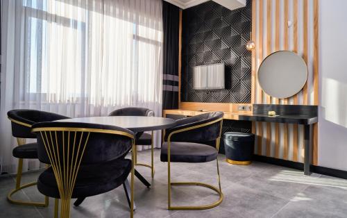 a dining room with a table and chairs and a mirror at Buyuk Truva Hotel in Canakkale