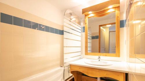 uma casa de banho com um lavatório, um espelho e uma banheira em V du Bachat Asters E11 - Appt 6 pers em Chamrousse