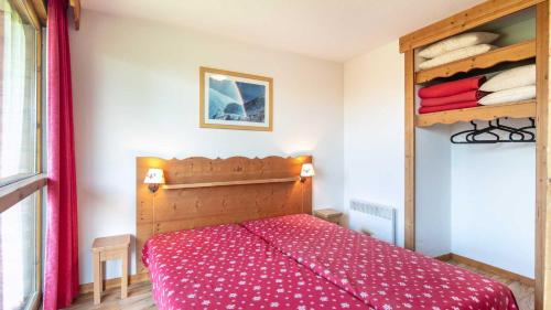 um quarto com uma cama com uma colcha vermelha em V du Bachat Asters E11 - Appt 6 pers em Chamrousse