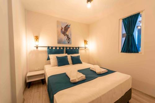 a bedroom with a large bed with blue pillows at Kamkat Otel in Kemer