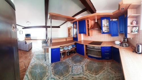 a kitchen with blue cabinets and a stove top oven at Pokoje pod Dębem Grzybowo in Grzybowo
