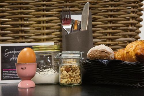 een tafel met een mand met eten en een vork en mes bij Domburg Holiday Resort in Domburg