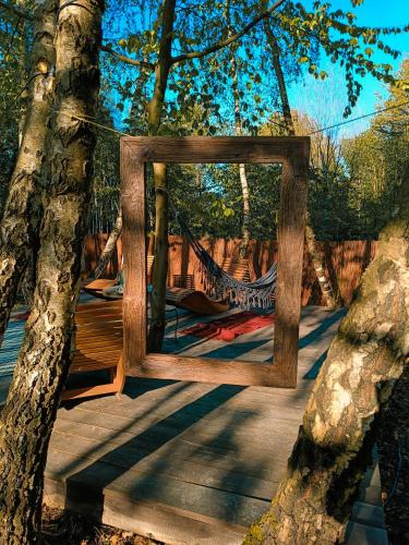 a wooden frame hanging from a tree in a hammock at Jurty z widokiem, prywatna balia- DZIKOLAS GLAMPING in Krasnobród