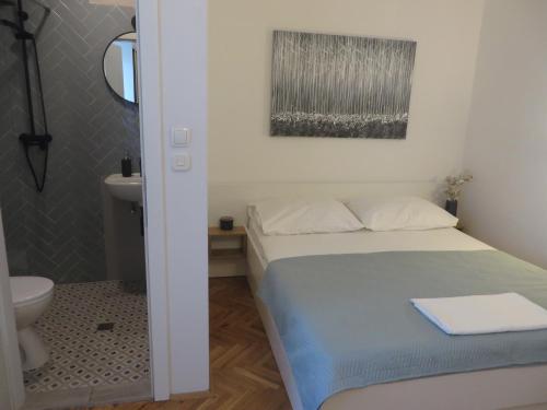 帕科坦Apartments Tonka的一间带床和浴室的小卧室