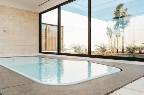 a swimming pool in a room with windows at Masseria Corsano in Nardò