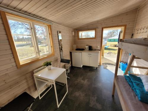 a tiny house with a desk and a kitchen at Tydingesjöns Camping & Festplats in Broby