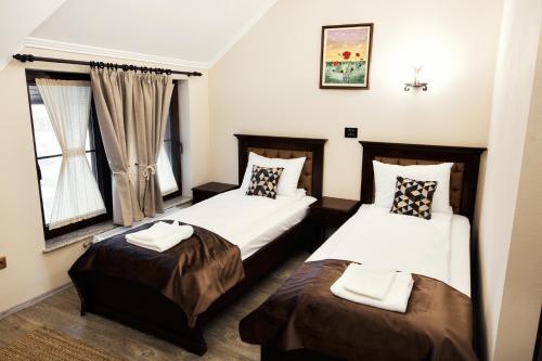 a hotel room with two beds and a window at Pensiunea Amurg in Odoreu