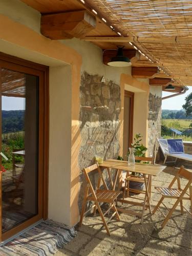 a patio with a table and chairs on a house at Casale Gatta Morena in Pianiano