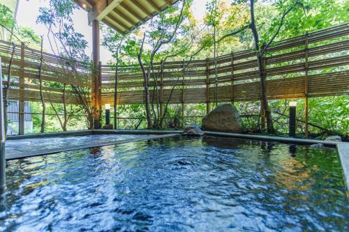 a swimming pool in a house with a roof at Shirasagiyu Tawaraya in Kaga