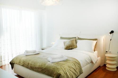 ein Schlafzimmer mit einem weißen Bett und Handtüchern darauf in der Unterkunft Luxury Apartment with Exceptional View in Athen