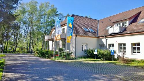 un bâtiment arborant des drapeaux sur le côté d'une route dans l'établissement Ostsee Ferienappartement Dierhagen-Strand, à Dierhagen