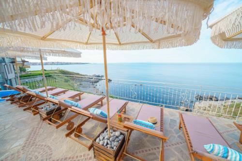 索佐波爾的住宿－DOLPHIN BAY BOUTIQUE COMPLEX Sozopol，海滩上一把遮阳伞下的椅子