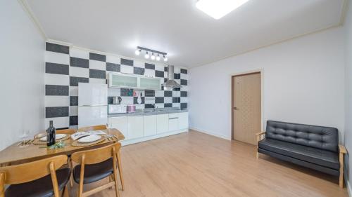 a kitchen and dining room with a table and a couch at Maremonte Pension in Geoje 