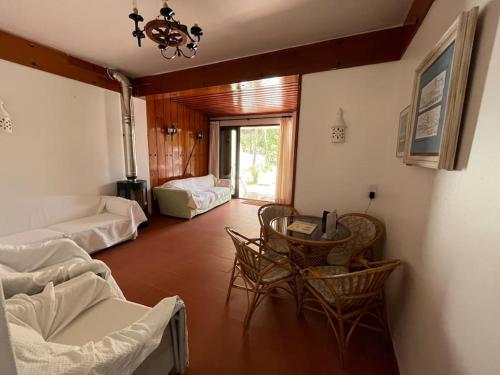 sala de estar con sofá, mesa y sillas en Villa típica ideal para as suas férias em família! en Monte Gordo