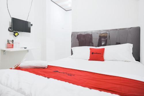 Un dormitorio con una cama con una almohada roja. en RedDoorz near Jalan Perintis Kemerdekaan Lampung, en Tanjungkarang