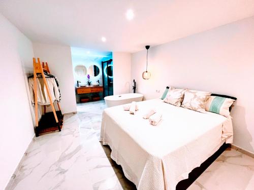 Un dormitorio blanco con una cama y una bañera. en Garden Boutique, en Mijas Costa