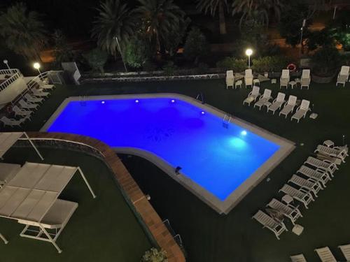 a large swimming pool with lounge chairs and sidx sidx sidx at Apartamentos Las Fuentes in Castropol