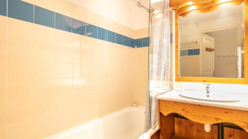 une salle de bain avec un lavabo, une baignoire et un miroir dans l'établissement V du Bachat Sorbiers E32 - Appt 6 pers, à Chamrousse