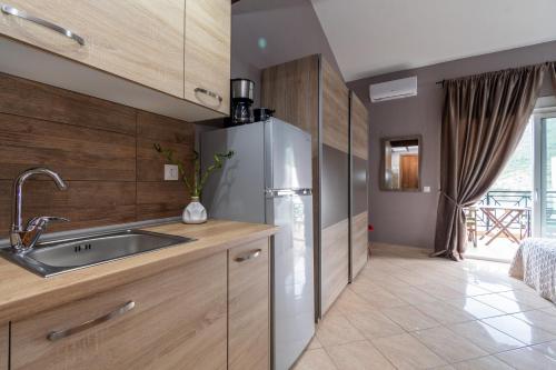 a kitchen with a stainless steel refrigerator and a sink at Studios Diogenis in Porto Koufo