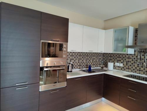 a kitchen with wooden cabinets and stainless steel appliances at Luxury Seaview Mellieha Apartment in Mellieħa