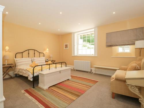a bedroom with a bed and a couch at The Garden Flat in Bridport