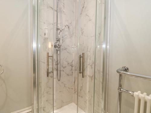 a bathroom with a shower with a glass door at The Garden Flat in Bridport