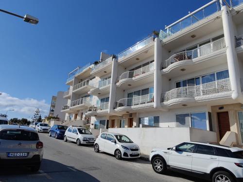 a row of cars parked in front of a building at Luxury Seaview Mellieha Apartment in Mellieħa