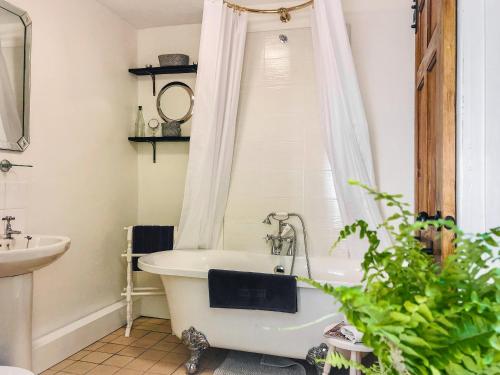 y baño con bañera blanca y lavamanos. en Diglis Lock Cottage en Worcester
