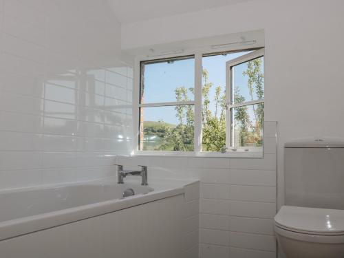 uma casa de banho branca com um lavatório e um WC em White Horse Cottage em Weymouth
