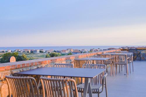 a row of tables and chairs on a balcony with the ocean at Akrolithos Luxury Suites & Spa in Flogita