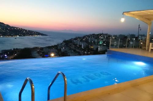 a large swimming pool with a view of the ocean at MAGNIFICENT VIEW with Private Pool & Piano, 3 Bedroom Villa, MIN 4 nigths in Gundogan