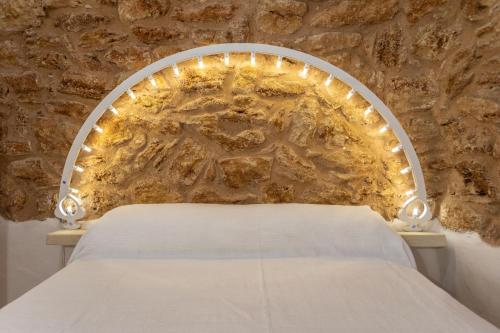 Posto letto in camera con parete in pietra. di Federico Holidays - Bed & Breakfast con piscina a Racale