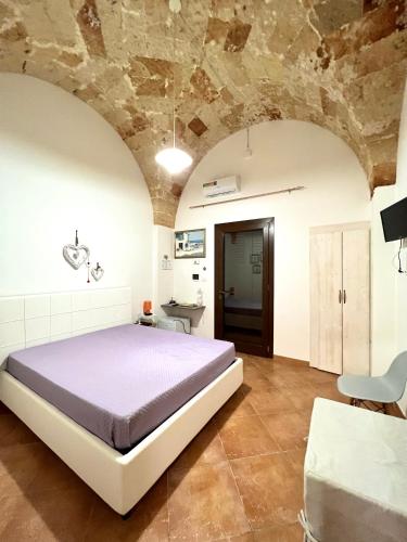 a bedroom with a bed and a stone wall at Corte La Rosa in Nardò