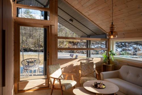 - un salon avec une terrasse couverte et une balançoire dans l'établissement Jølstraholmen Camping og Hytter, à Vassenden