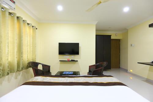 a bedroom with a bed and a tv on the wall at MADRASl AIRPORT HOTEL - NEAR AlRPORT in Chennai