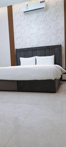 a bed with a black frame and white pillows at شاليهات أبيات الفندقية in Al Baha