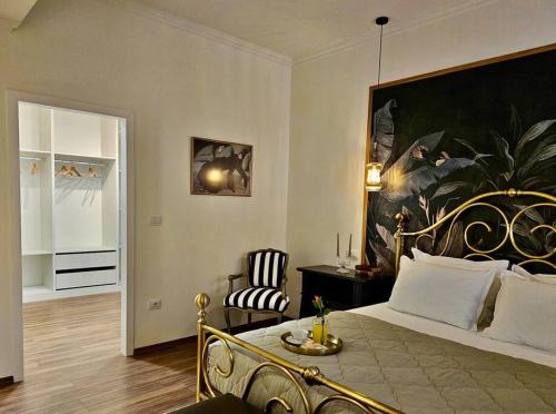 a bedroom with a bed with a large painting on the wall at NOVI's Luxury Apartment 2 in Gjirokastër